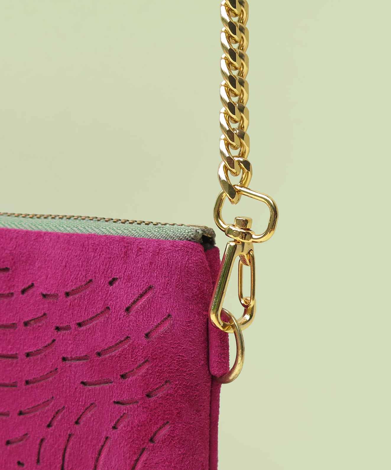 Cadena dorada removible con mosquetones oro sobre sobre clutch gamuza fucsia mujer Kaloskopic