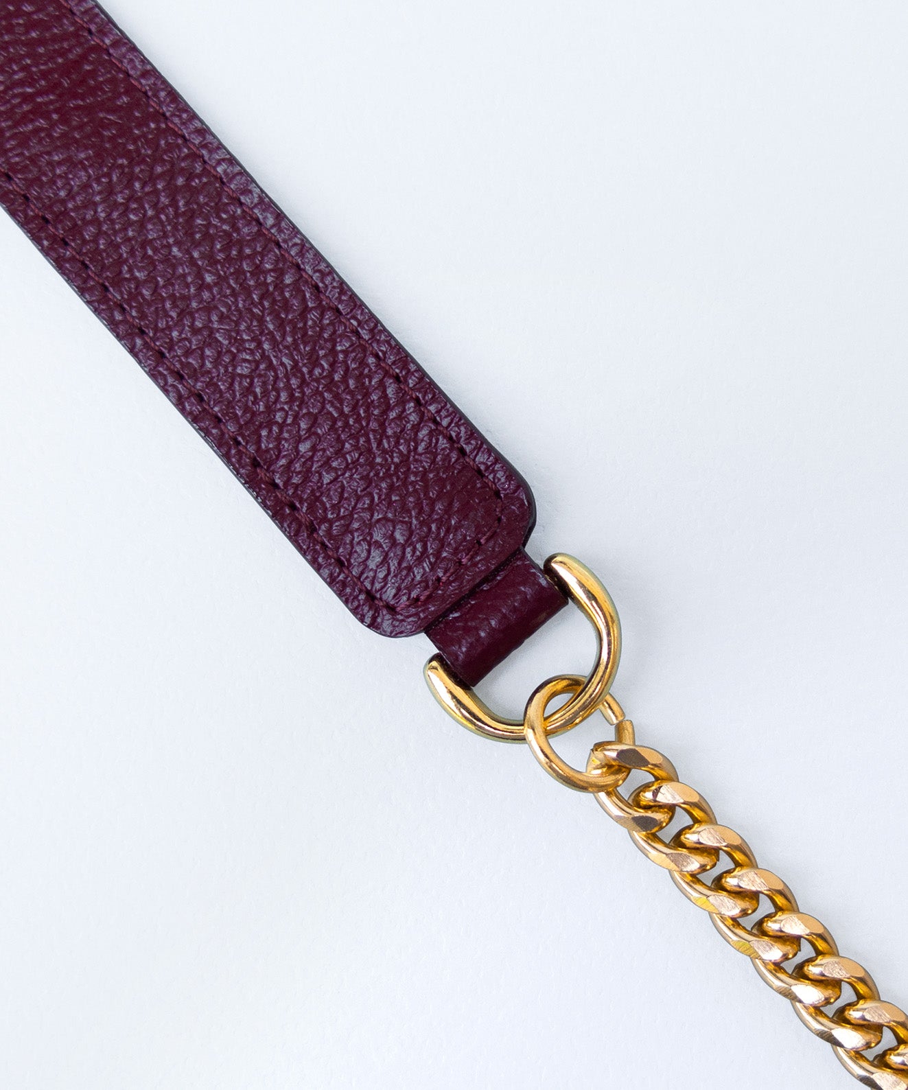 Detalle hombrera textura cuero vinotinto con cadena oro argollas doradas accesorio bolsos Kaloskopic