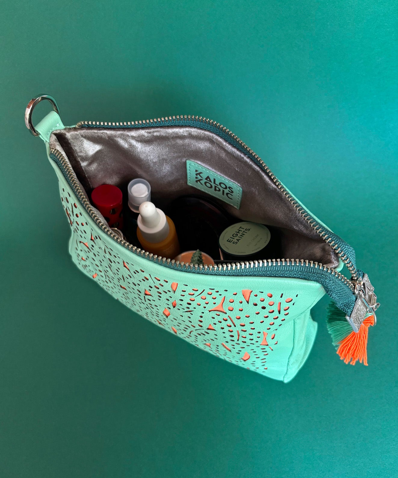 Interior cremallera cosmetiquera de viaje Maculata Kaloskopic cuero verde menta con maquillaje y skincare 