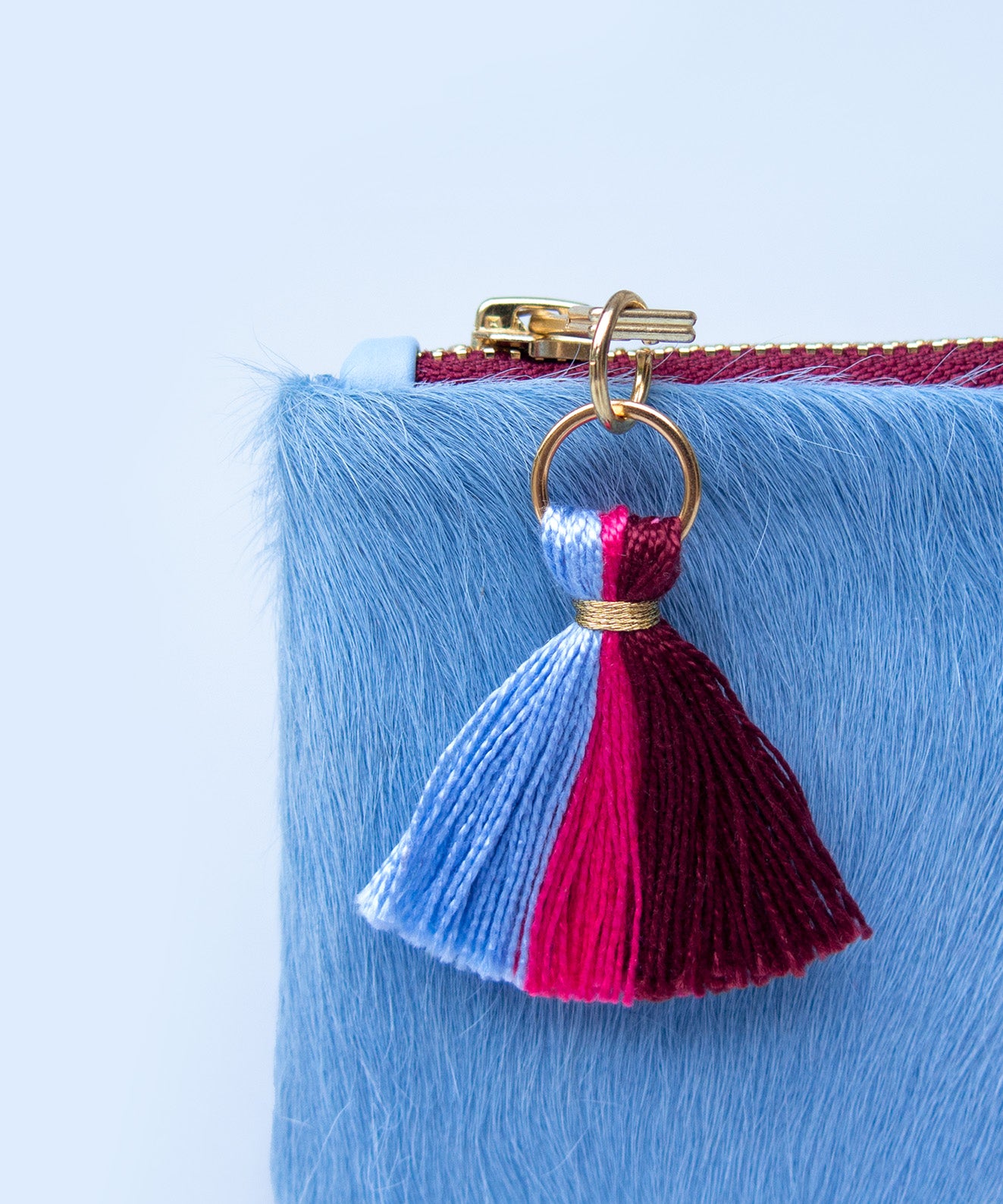 Detalle borla monedero Aura Blue Kaloskopic cuero pelo azul claro herrajes acabado oro